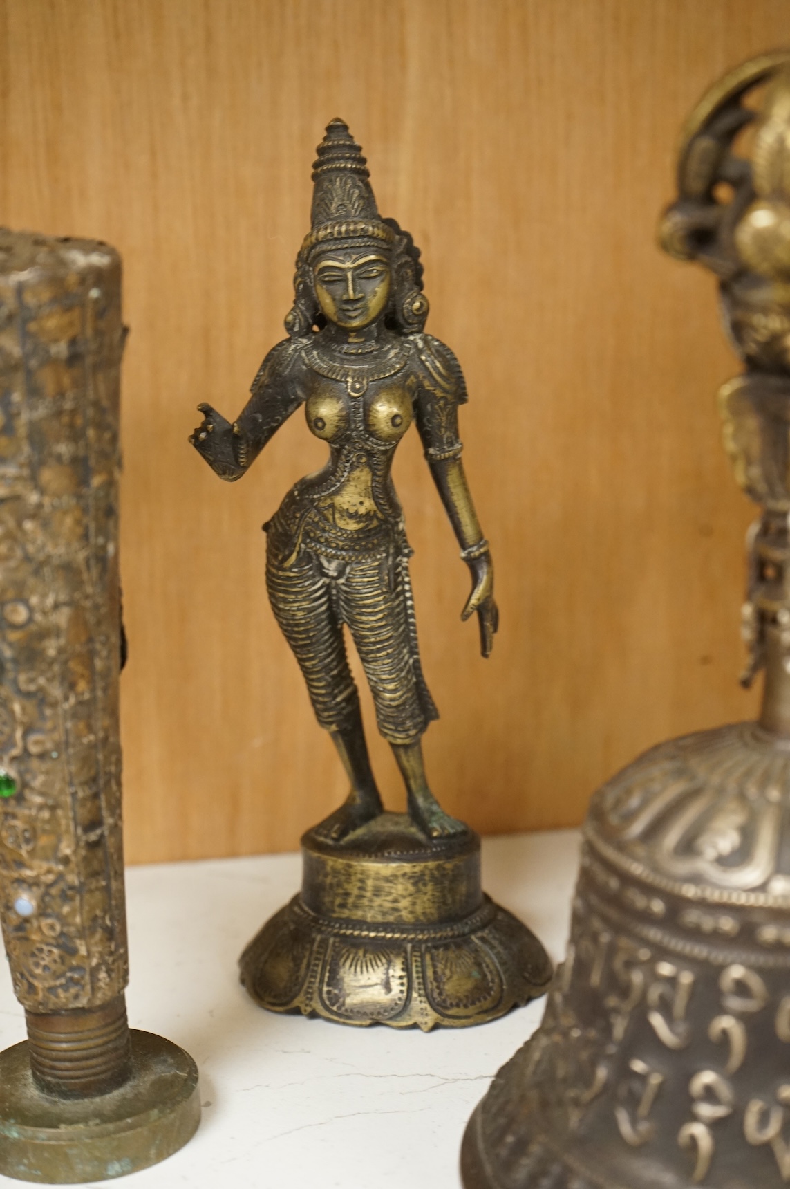 A group of Tibetan brass and mixed metal artefacts to include a brass vase with cabochon inset stones and figures of deities, largest 22cm high